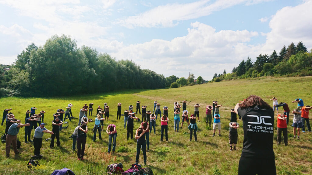 Gruppenteilnehmer bei einem Outdoor Gesundheitstag mit Teamaktivitäten